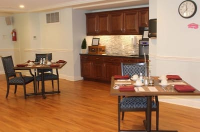 Dining room setup with tables and kitchen area