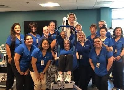 Staff and residents in a common area smiling together