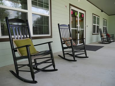Rocking chairs on a porch of a senior living facility