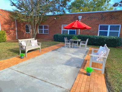 Outdoor seating area with benches and red umbrella