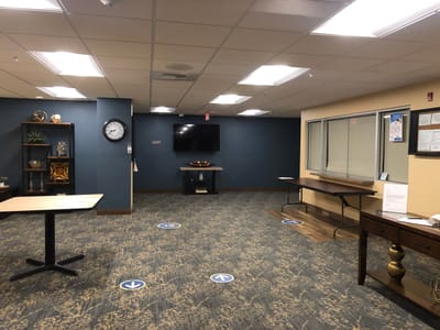 An empty common area with tables and a clock
