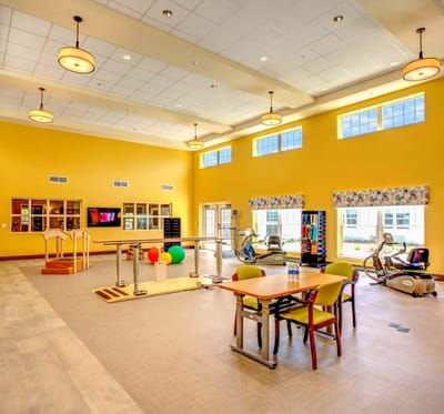 Bright activity room with exercise equipment and tables