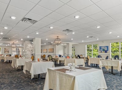 A well-lit dining area with tables set for meals