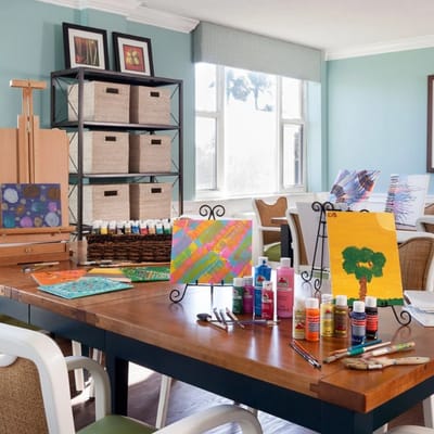 Art supplies and paintings set up in an activity room
