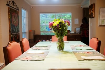Dining room table set for a meal with flowers