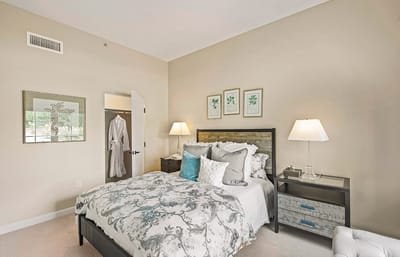 A cozy resident room with a well-made bed and decor