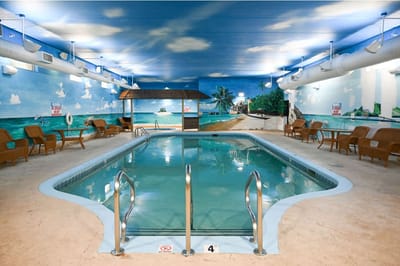 Indoor swimming pool area with beach mural