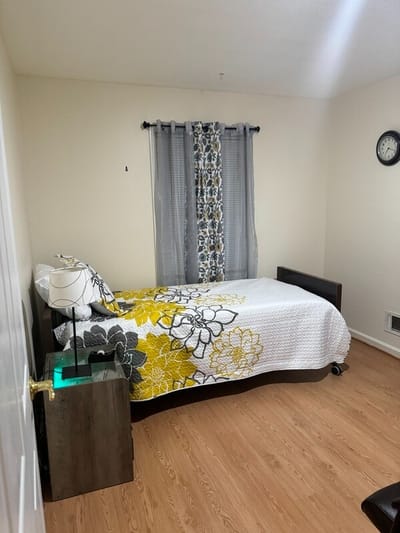 Cozy resident room with floral bedding and lamp
