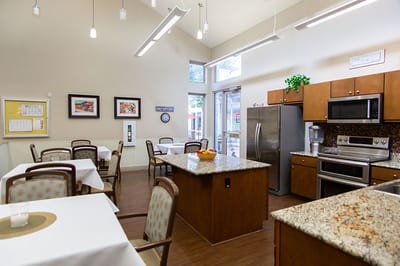 Interior view of a dining room with tables and kitchen area
