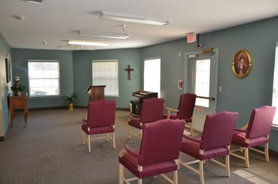 Lounge area with chairs, piano, and decorations