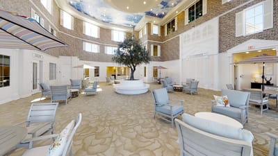 Bright common area with seating and a central tree