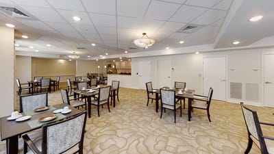 Bright dining room with tables and chairs set for meal service