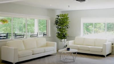 Bright common area with white sofas and plants