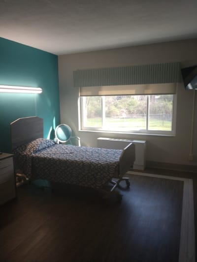 Private resident room with a hospital bed and window