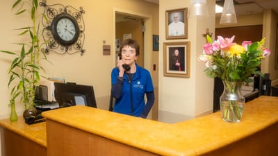 Staff member at the reception desk with flowers
