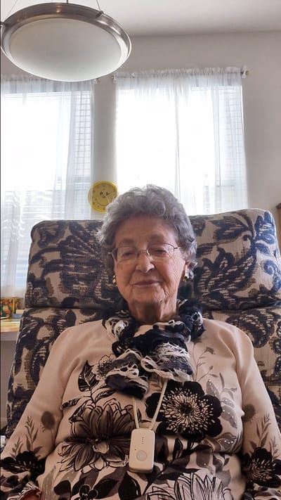 Resident smiling in a cozy chair with natural light