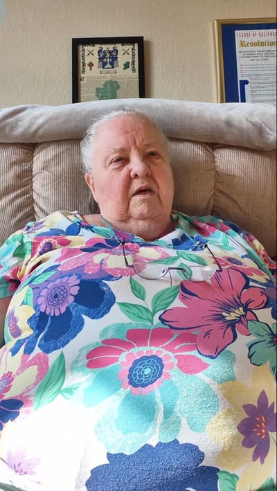 Resident sitting in a cozy chair wearing a floral shirt
