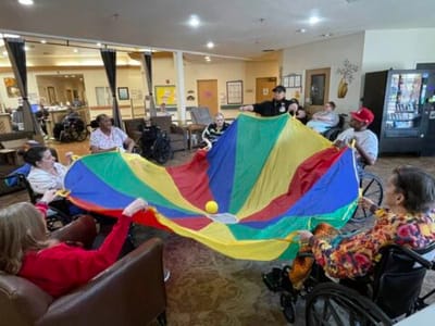 Residents engaging in a group activity with a colorful parachute