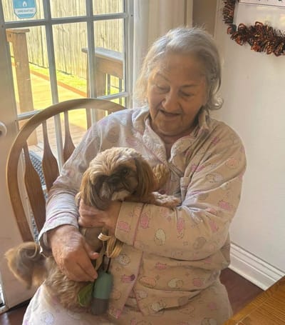Resident enjoying time with a small dog indoors