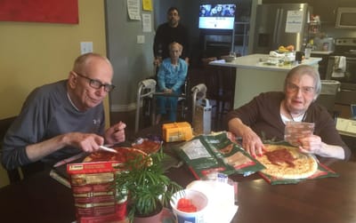 Residents enjoying pizza together in a dining area