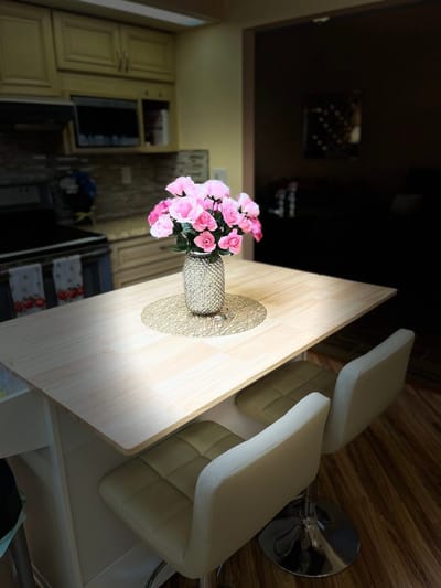 A well-lit kitchen table with flowers
