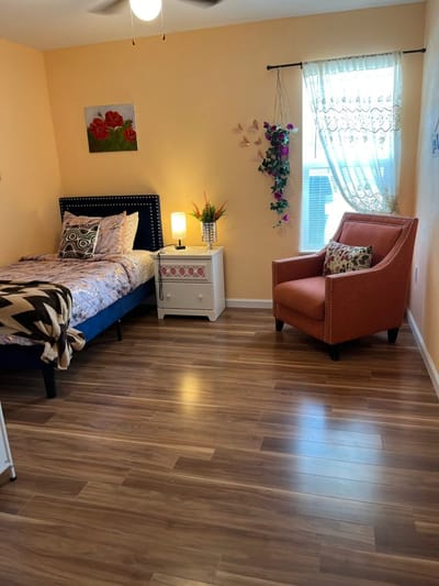 A cozy resident room with bed and armchair