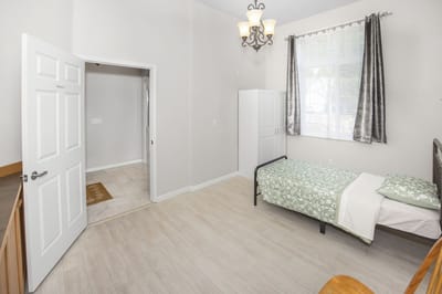 A private resident room with a bed and wardrobe