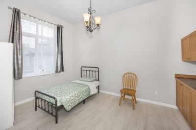 A private resident room with a bed and chair