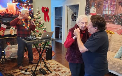A resident dancing with a staff member during a festive event