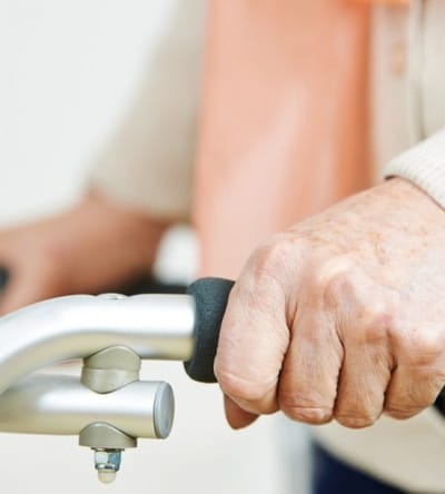 Close-up of an elderly person's hand on a walker
