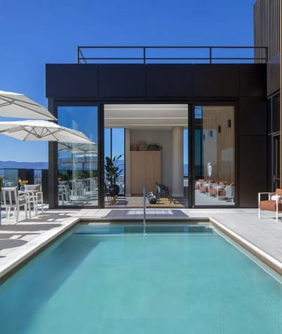 A modern pool area with seating and panoramic views
