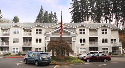 Exterior view of the facility with flag and parking area