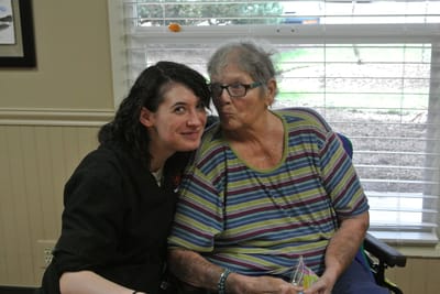 Staff member and resident smiling together indoors