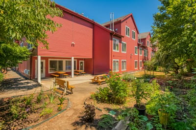 Exterior view of a colorful assisted living facility with garden