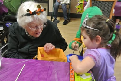 A senior woman and a young girl engaging in an activity together.