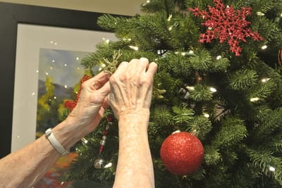 Hands decorating a Christmas tree
