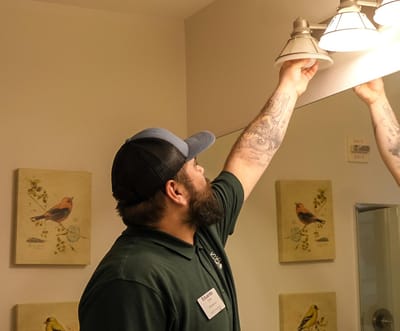 Staff member adjusting lighting in a facility room