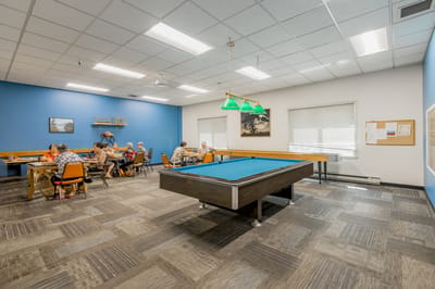 Residents enjoying activities in a bright common area