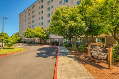 Exterior view of Kirkland Union Manors with trees and sign
