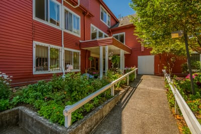 Exterior view of a senior living facility entrance with garden