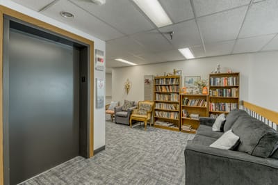 Interior view of a common area with seating and bookshelves