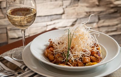 Gourmet pasta dish with wine in a dining setting