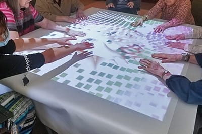 Residents engaging with a projection activity at a table