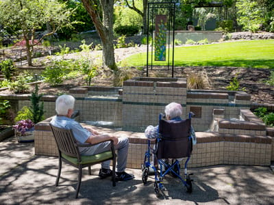 Two residents enjoying a peaceful outdoor space by a fountain