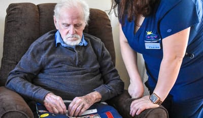 A resident engaged with staff member at a nursing home