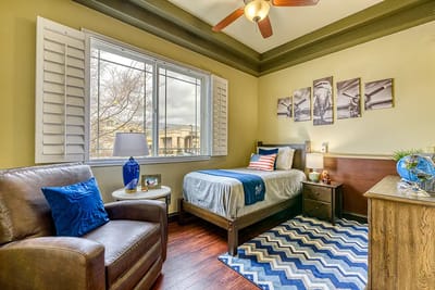 A bright and cozy resident room with a bed and chair