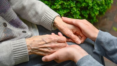 Two hands holding, symbolizing care and companionship.