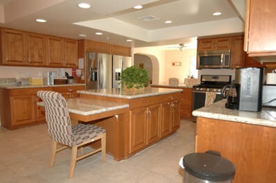 Bright kitchen area with wooden cabinetry and appliances