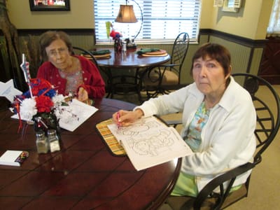 Two residents coloring in an activity area
