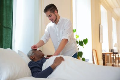 A caregiver attending to a resident in bed